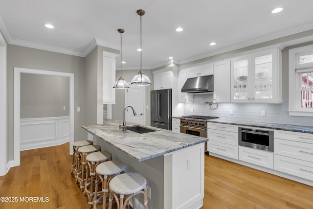 209 Sanborn Ave, Point Pleasant Beach, NJ 08742 - kitchen featuring stainless steel appliances, under cabinet range hood, a breakfast bar, white cabinets, and light stone counters