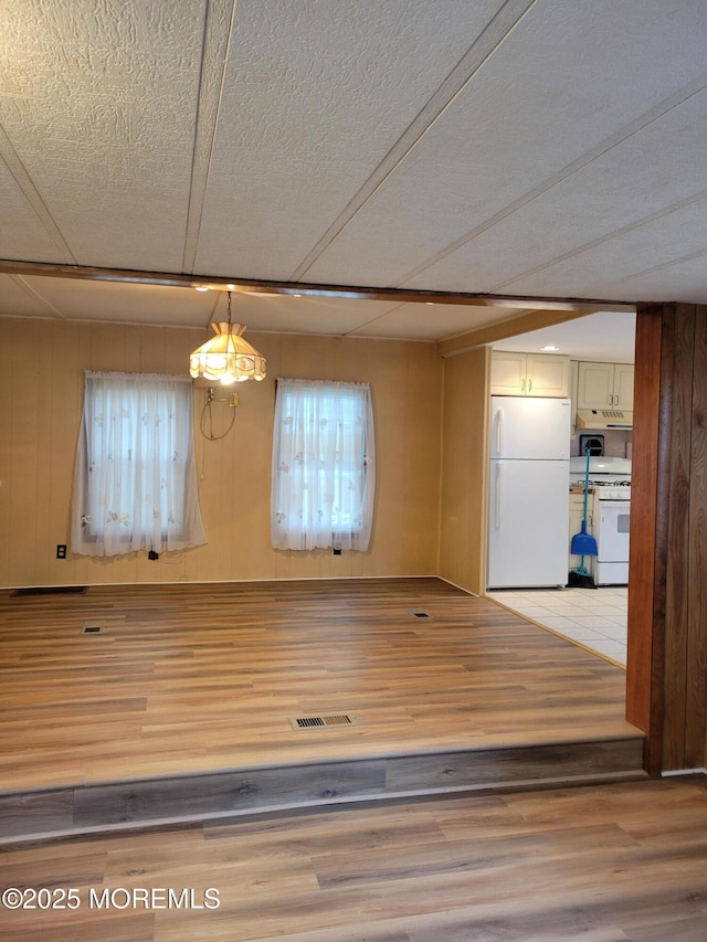 39 Antonia Dr, Jackson, NJ 08527 - unfurnished dining area featuring light wood-type flooring, a textured ceiling, and wood walls