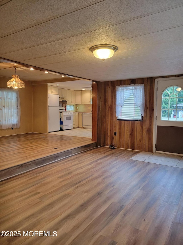 39 Antonia Dr, Jackson, NJ 08527 - unfurnished living room featuring light wood-style flooring, wood walls, and a textured ceiling