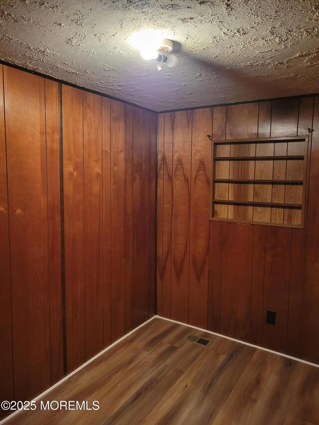 39 Antonia Dr, Jackson, NJ 08527 - empty room with wood finished floors, a textured ceiling, and wood walls