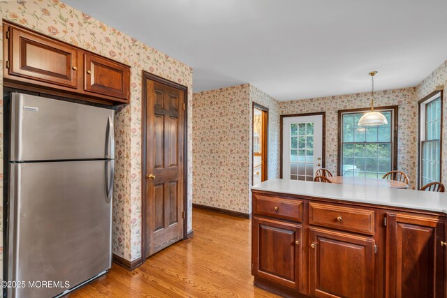 406 Bell Pl, Sea Girt, NJ 08750 - kitchen with freestanding refrigerator, wallpapered walls, light wood-style floors, light countertops, and pendant lighting