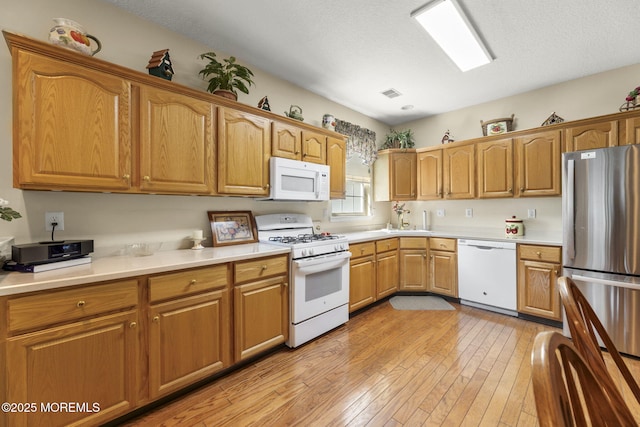 17 Evergreen Springs Dr, Lakewood, NJ 08701 - kitchen featuring white appliances, light wood-style floors, light countertops, brown cabinetry, and a textured ceiling