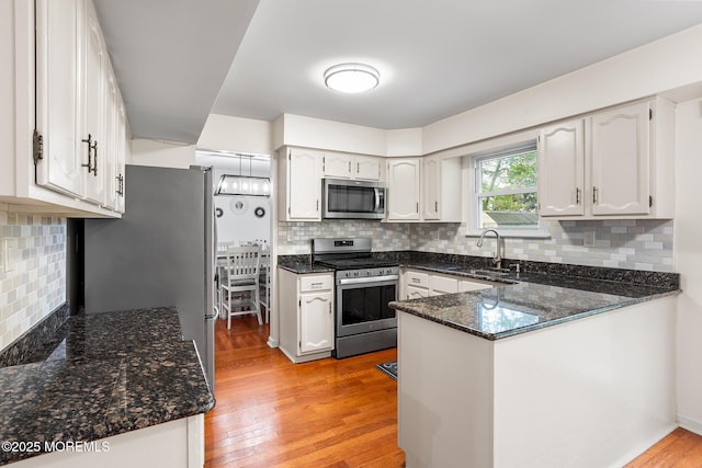 8 Mendon Dr, Howell, NJ 07731 - kitchen featuring stainless steel appliances, a peninsula, decorative backsplash, and dark stone counters