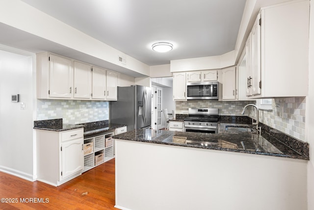 8 Mendon Dr, Howell, NJ 07731 - kitchen with stainless steel appliances, wood finished floors, a peninsula, backsplash, and dark stone counters