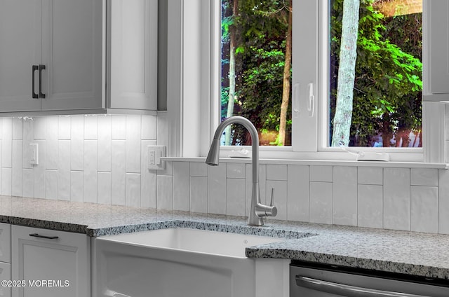 817 Naryshkin Way, Toms River, NJ 08753 - kitchen view of stainless steel dishwasher, decorative backsplash, and light stone countertops