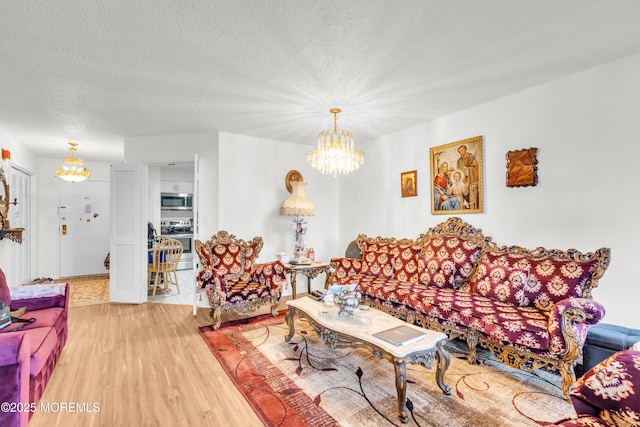 2508 Harmon Cv, Secaucus, NJ 07094 - living room with a chandelier, light wood-type flooring, and a textured ceiling