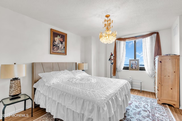 2508 Harmon Cv, Secaucus, NJ 07094 - bedroom featuring wood finished floors, a chandelier, and a textured ceiling