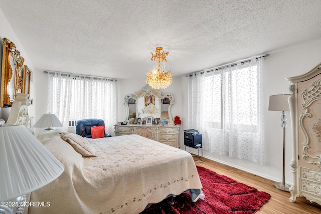 2508 Harmon Cv, Secaucus, NJ 07094 - bedroom featuring multiple windows, a textured ceiling, light wood-type flooring, and a chandelier