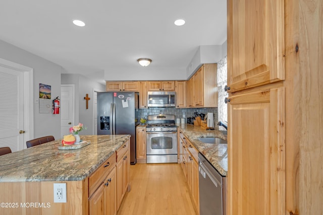 1506 Beverly Rd, Forked River, NJ 08731 - kitchen featuring stainless steel appliances, light wood-type flooring, decorative backsplash, light stone countertops, and a center island