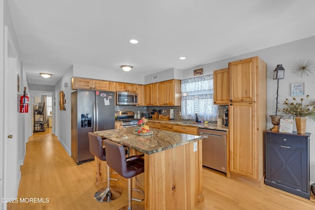 1506 Beverly Rd, Forked River, NJ 08731 - kitchen with appliances with stainless steel finishes, light wood finished floors, a breakfast bar area, decorative backsplash, and recessed lighting