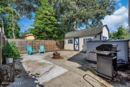 1506 Beverly Rd, Forked River, NJ 08731 - fenced backyard featuring a shed, a patio, a grill, and a fire pit
