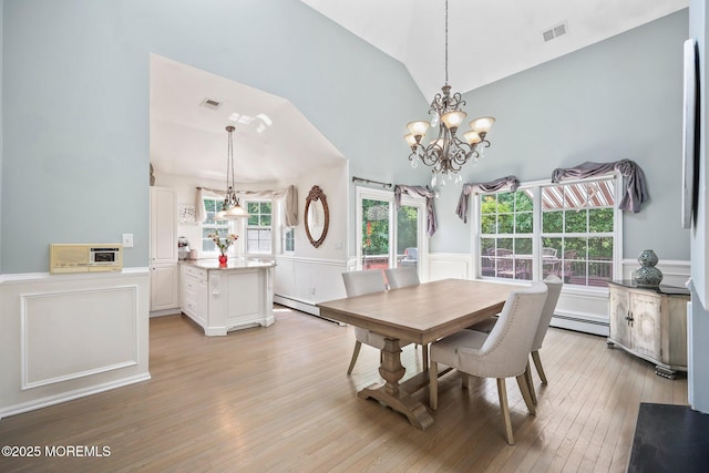 96 Kentucky Way, Freehold, NJ 07728 - dining room featuring healthy amount of natural light, a chandelier, a wainscoted wall, vaulted ceiling, and light wood finished floors