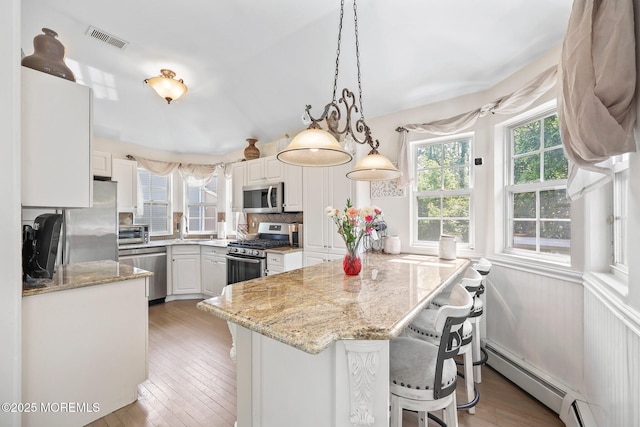 96 Kentucky Way, Freehold, NJ 07728 - kitchen featuring appliances with stainless steel finishes, a peninsula, a breakfast bar, white cabinetry, and light wood-style floors