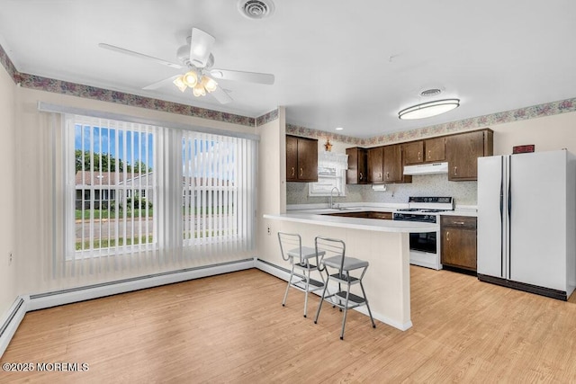 68 Barbados Dr S, Toms River, NJ 08757 - kitchen featuring white appliances, under cabinet range hood, dark brown cabinetry, a peninsula, and light countertops