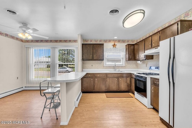 68 Barbados Dr S, Toms River, NJ 08757 - kitchen featuring freestanding refrigerator, range with gas stovetop, baseboard heating, a peninsula, and light wood finished floors