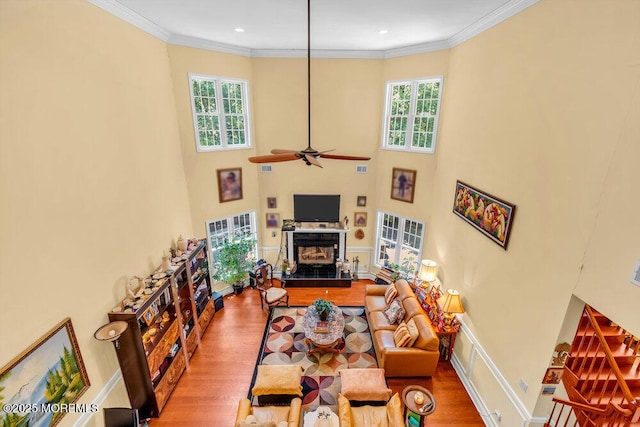 312 Clearstream Rd, Jackson, NJ 08527 - living area with healthy amount of natural light, wood finished floors, a glass covered fireplace, ornamental molding, and ceiling fan