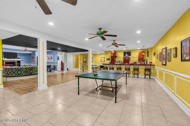 312 Clearstream Rd, Jackson, NJ 08527 - playroom featuring a ceiling fan, a fireplace, recessed lighting, light tile patterned floors, and a wainscoted wall