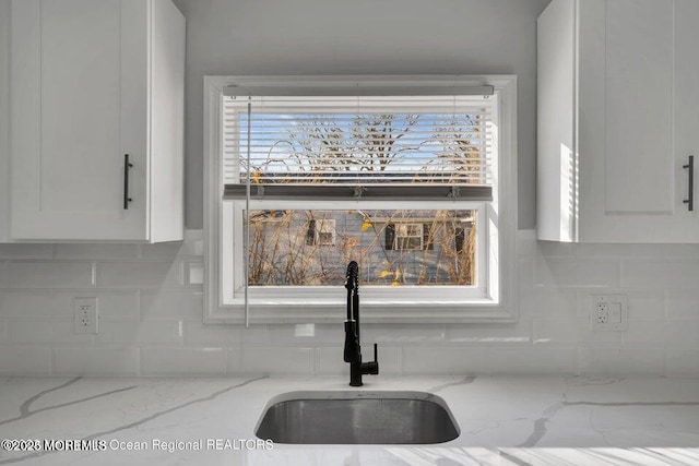 58 Chadwick Ave, Toms River, NJ 08753 - kitchen view of white cabinetry, decorative backsplash, and light stone countertops