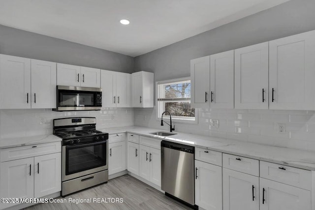 58 Chadwick Ave, Toms River, NJ 08753 - kitchen with appliances with stainless steel finishes, white cabinets, light stone counters, recessed lighting, and tasteful backsplash