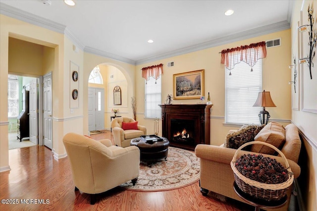 86 Wild Dunes Way, Jackson, NJ 08527 - living room featuring wood finished floors, healthy amount of natural light, a warm lit fireplace, ornamental molding, and recessed lighting