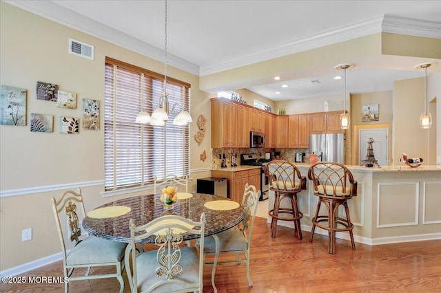 86 Wild Dunes Way, Jackson, NJ 08527 - dining space with a chandelier, crown molding, and light wood-style floors
