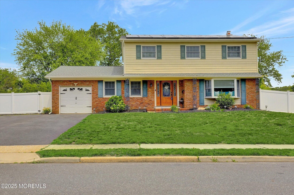18 Taunton Dr, Howell, NJ 07731 - view of front of house featuring brick siding, driveway, a garage, and roof mounted solar panels