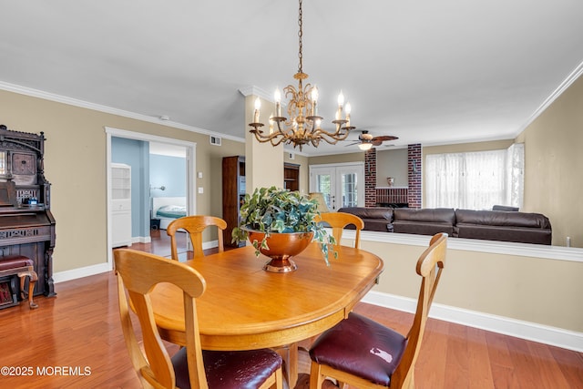 61 Mansfield Ave, Manchester, NJ 08759 - dining space with a chandelier, a wood stove, wood finished floors, crown molding, and ceiling fan