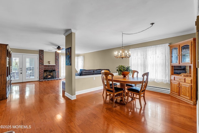 61 Mansfield Ave, Manchester, NJ 08759 - dining room with a baseboard radiator, wood finished floors, a fireplace, a ceiling fan, and ornamental molding