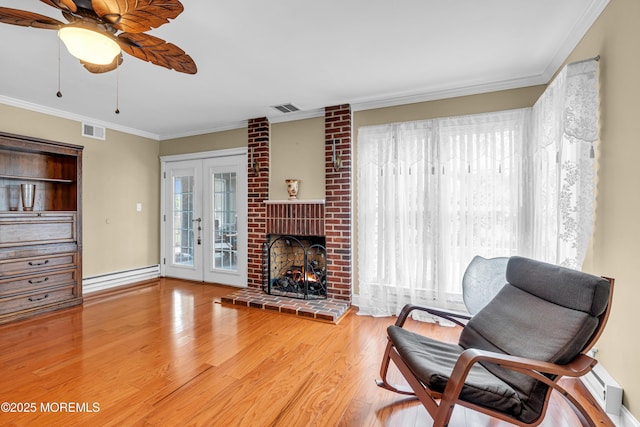61 Mansfield Ave, Manchester, NJ 08759 - living room featuring a ceiling fan, ornamental molding, wood finished floors, a brick fireplace, and baseboard heating