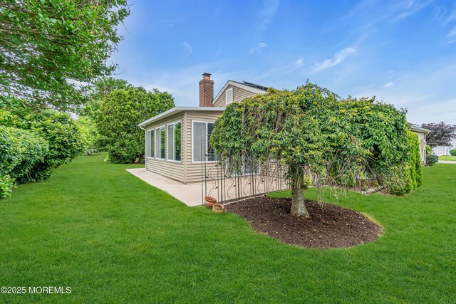 61 Mansfield Ave, Manchester, NJ 08759 - view of property exterior with a yard, a chimney, and a patio area