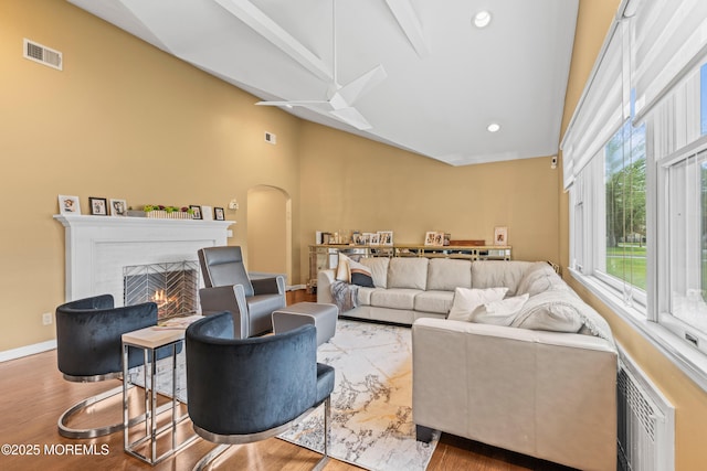 367 Kirby Ave, Long Branch, NJ 07740 - living room with high vaulted ceiling, arched walkways, a lit fireplace, wood finished floors, and a ceiling fan