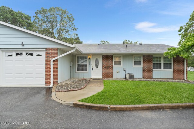 1058A Argyll Cir, Lakewood, NJ 08701 - ranch-style house featuring an attached garage, asphalt driveway, brick siding, and a front lawn