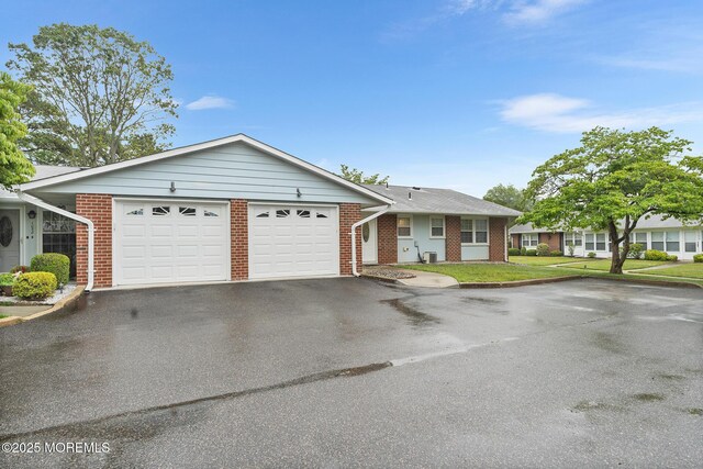 1058A Argyll Cir, Lakewood, NJ 08701 - single story home featuring driveway, an attached garage, brick siding, and a front lawn