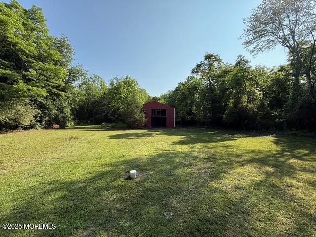 626 N County Line Rd, Jackson, NJ 08527 - view of grassy yard with an outdoor structure and a view of trees