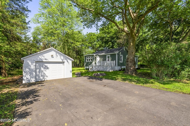 23 Bittner Rd, Millstone, NJ 08535 - view of front of property with an outdoor structure, a detached garage, asphalt driveway, a wooden deck, and view of wooded area