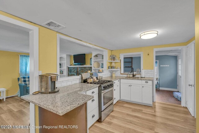 200 Sams Rd, Jackson, NJ 08527 - kitchen with stainless steel gas range oven, white cabinets, light stone counters, light wood finished floors, and open shelves