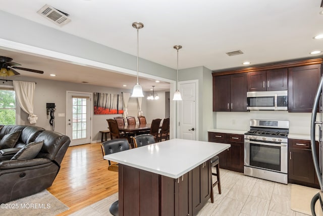 27 Gillette St, Keansburg, NJ 07734 - kitchen featuring appliances with stainless steel finishes, open floor plan, light countertops, a kitchen breakfast bar, and recessed lighting