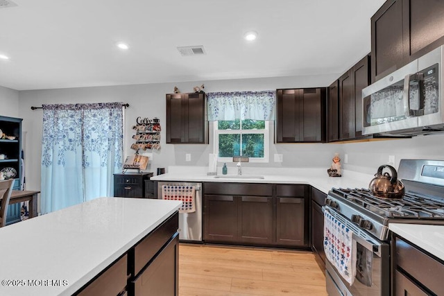 703 Cyprus Ct, Forked River, NJ 08731 - kitchen featuring stainless steel appliances, light countertops, light wood-style flooring, recessed lighting, and dark brown cabinetry