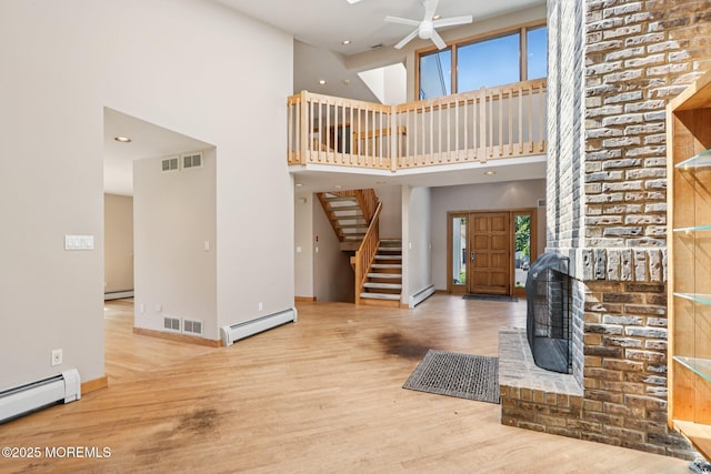 1120 Pennsylvania Ave, Manasquan, NJ 08736 - unfurnished living room with a baseboard heating unit, a ceiling fan, wood finished floors, a towering ceiling, and recessed lighting