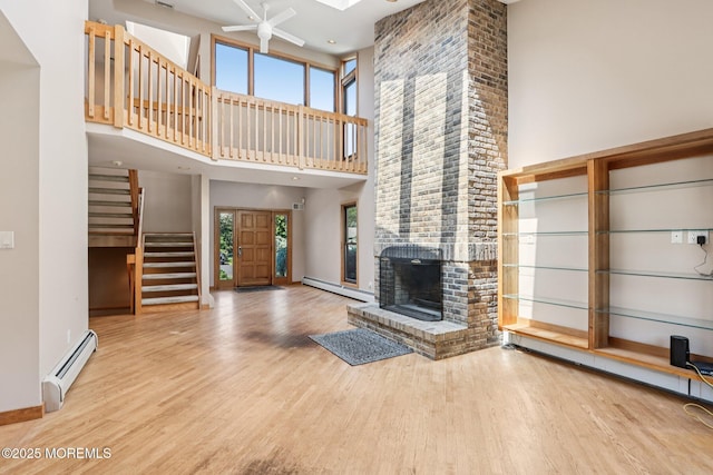1120 Pennsylvania Ave, Manasquan, NJ 08736 - unfurnished living room with a baseboard radiator, stairway, a high ceiling, wood finished floors, and healthy amount of natural light