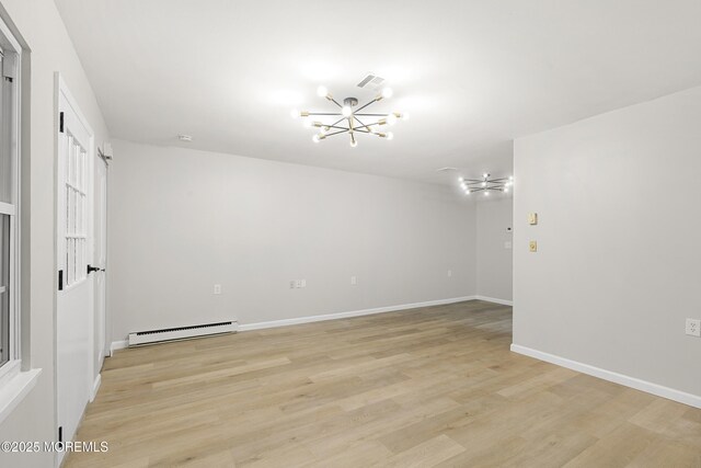 1034 Aberdeen Dr Unit E, Lakewood, NJ 08701 - empty room featuring a baseboard heating unit, a chandelier, and light wood-type flooring