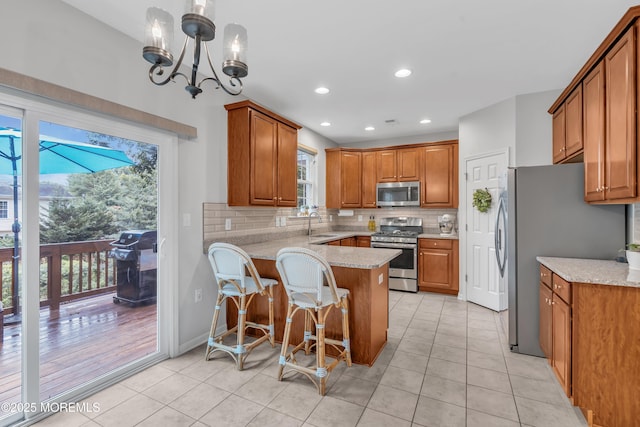 249 Chickadee Ct Unit 1000, Freehold, NJ 07728 - kitchen with stainless steel appliances, a peninsula, light tile patterned floors, brown cabinets, and recessed lighting