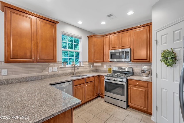 249 Chickadee Ct Unit 1000, Freehold, NJ 07728 - kitchen with stainless steel appliances, decorative backsplash, brown cabinets, light tile patterned flooring, and recessed lighting