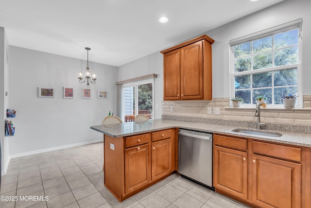 249 Chickadee Ct Unit 1000, Freehold, NJ 07728 - kitchen featuring dishwasher, brown cabinetry, a peninsula, light stone counters, and a chandelier