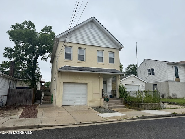 77 Center Ave, Keansburg, NJ 07734 - view of front of home with an attached garage, stucco siding, and driveway