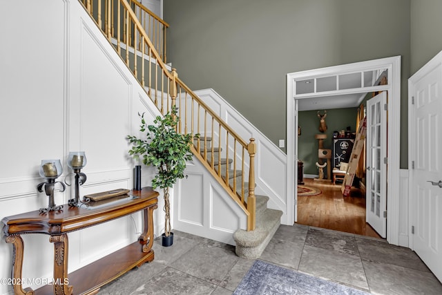 1020 Aumack Rd, Jackson, NJ 08527 - entryway with a decorative wall, stairway, stone finish floors, a wainscoted wall, and french doors