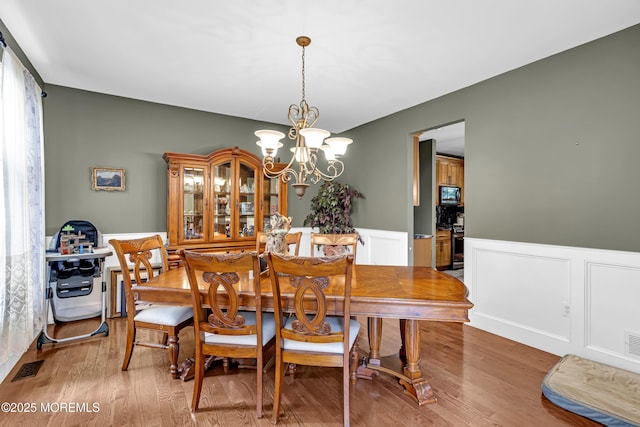 1020 Aumack Rd, Jackson, NJ 08527 - dining room with a wainscoted wall, a chandelier, light wood-style flooring, and a decorative wall