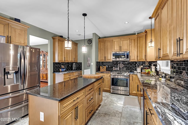 1020 Aumack Rd, Jackson, NJ 08527 - kitchen featuring appliances with stainless steel finishes, tasteful backsplash, dark stone countertops, decorative light fixtures, and a kitchen island