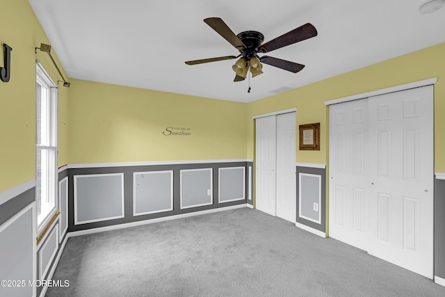 1020 Aumack Rd, Jackson, NJ 08527 - unfurnished bedroom with multiple closets, wainscoting, carpet floors, a ceiling fan, and a decorative wall
