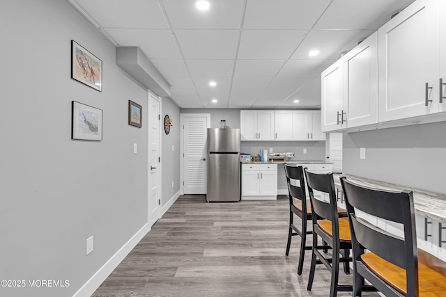 1020 Aumack Rd, Jackson, NJ 08527 - kitchen featuring freestanding refrigerator, recessed lighting, white cabinetry, wood finished floors, and a drop ceiling